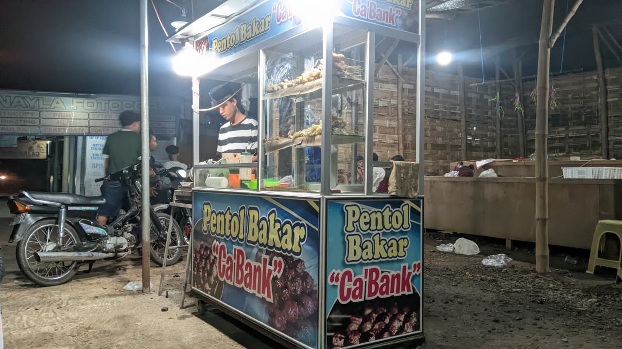 Sejumlah remaja Karang Taruna Dusun Modongan melayani pembeli di lapak Pentol Bakar Ca’Bank yang dikelola secara bersama sebagai upaya pemberdayaan ekonomi anak muda desa. (Foto: Dian Wahyu)
