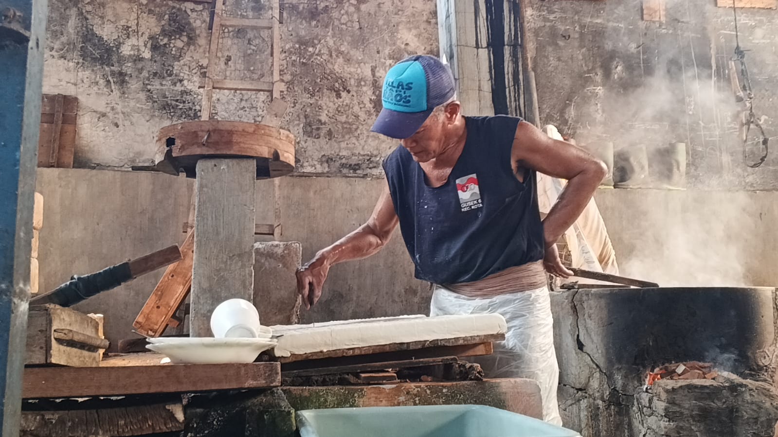 Perajin tahu di Kampung Tahu Tinalan Kota Kediri sedang memotong tahu setelah melalui proses pengepresan